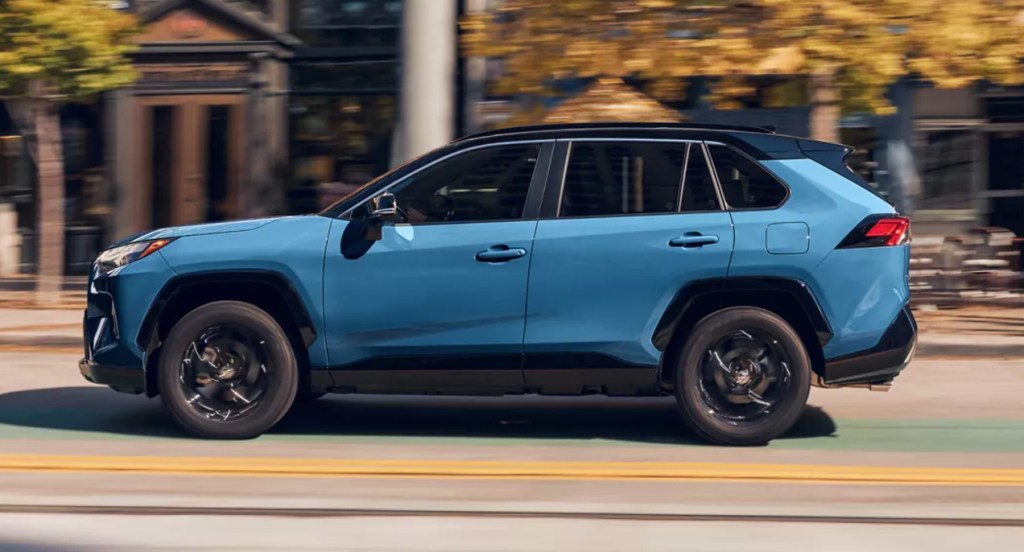 A blue 2022 Toyota RAV4 Hybrid XSE is driving on the road. 