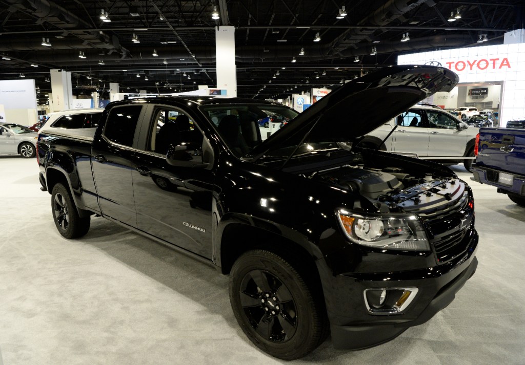 A Chevy Colorado mid-size truck is on display at an auto show.
