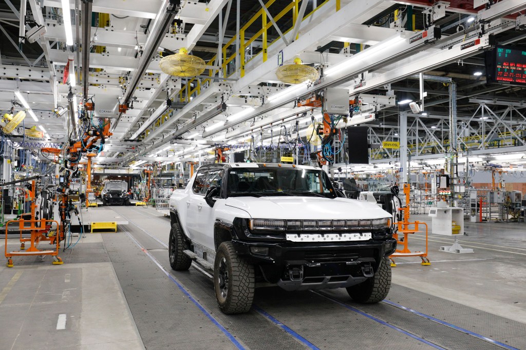 A GMC Hummer pickup trucks the production line in a factory.