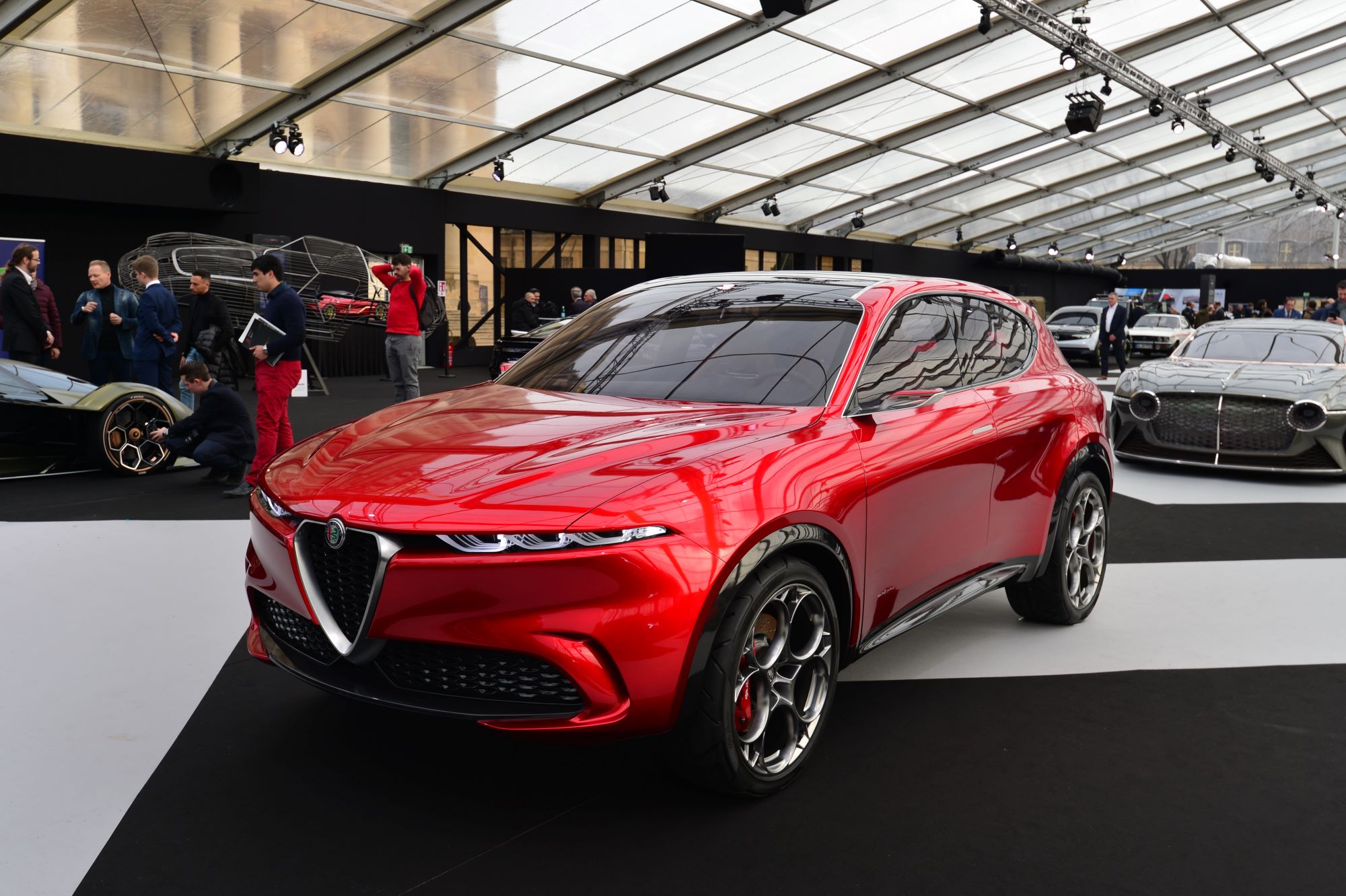 A red 2023 Alfa Romeo Tonale parked in a building with a glass ceiling. a