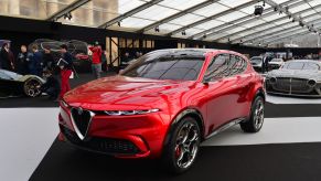 A red 2023 Alfa Romeo Tonale parked in a building with a glass ceiling. a