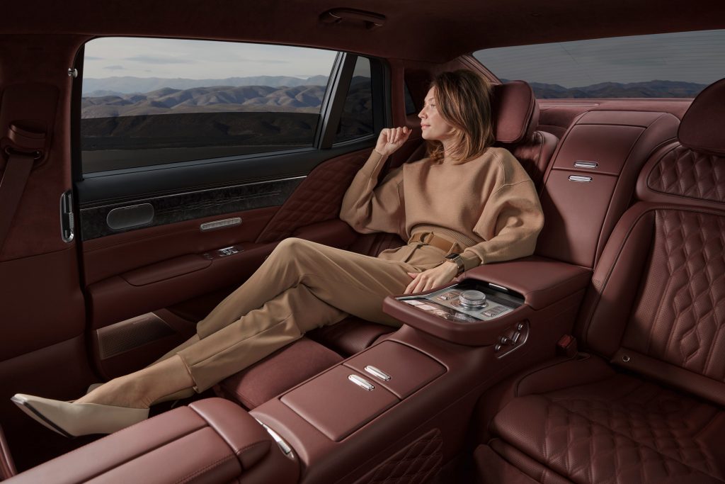 woman reclining in the back seat of the 2023 Genesis G90