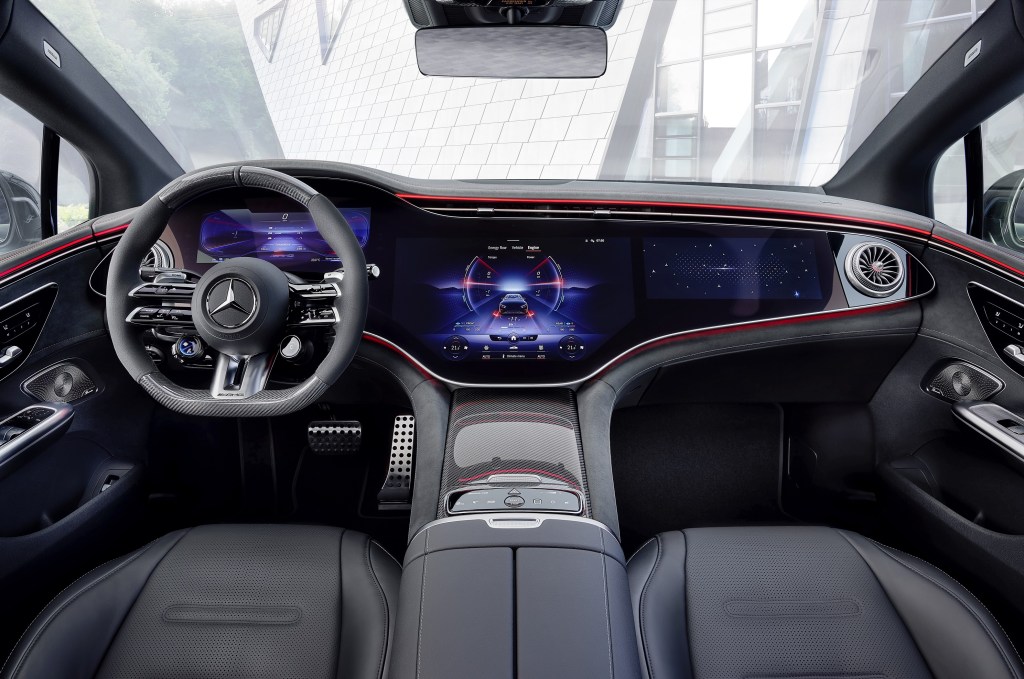 The black-and-red-upholstered front seats and dashboard of a 2023 Mercedes-AMG EQE with the optional Hyperscreen