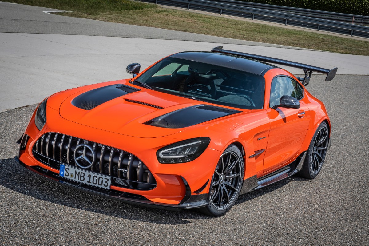 A 3/4 front view of an orange and black 2021 Mercedes-AMG GT Black Series car parked on pavement.