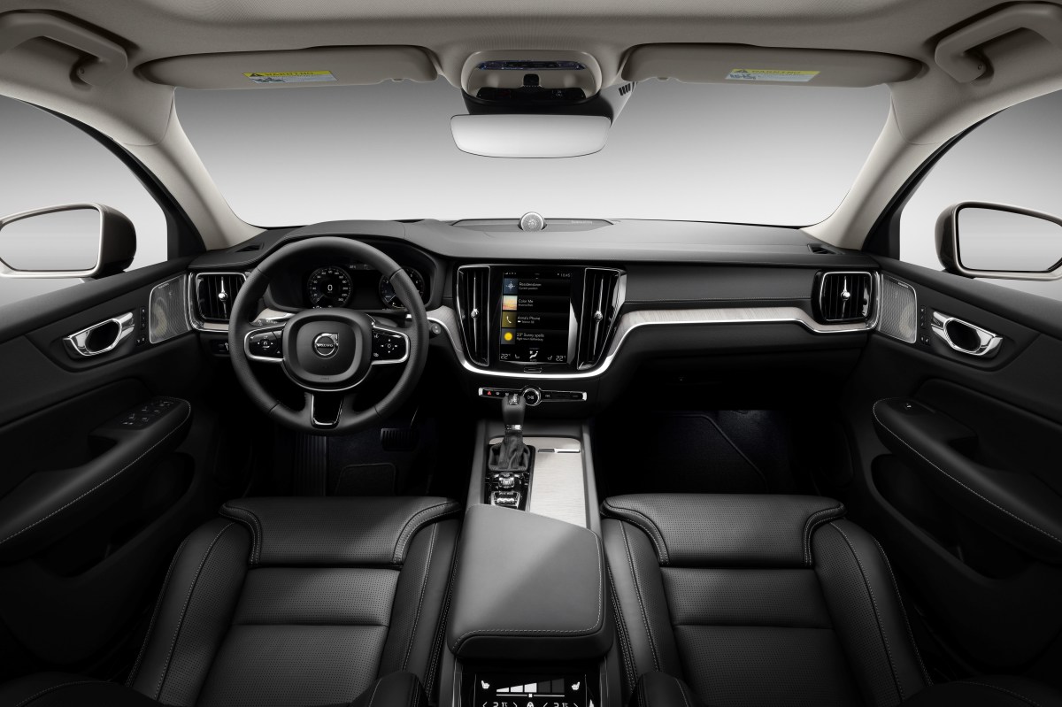 An interior view of a Volvo V60 Cross Country showing the front seats, steering wheel, gauges, dashboard, and infotainment system.
