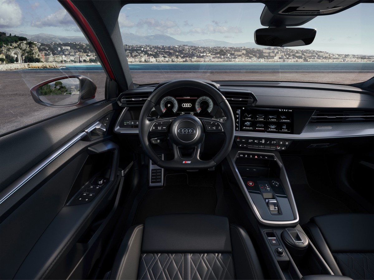 A view of the interior cockpit of a 2022 Audi A3 sedan showing the steering wheel, instrument cluster and dashboard.