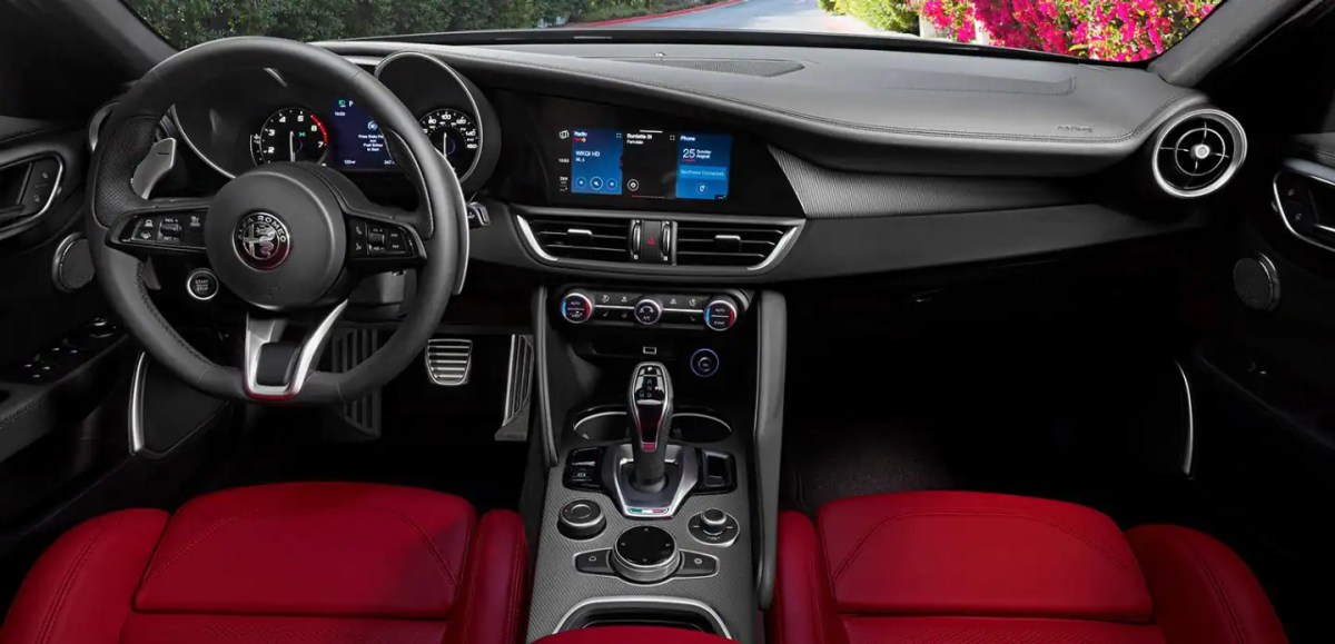 An interior view showing the dashboard, steering wheel and seats of a 2022 Alfa Romeo Giulia sedan.