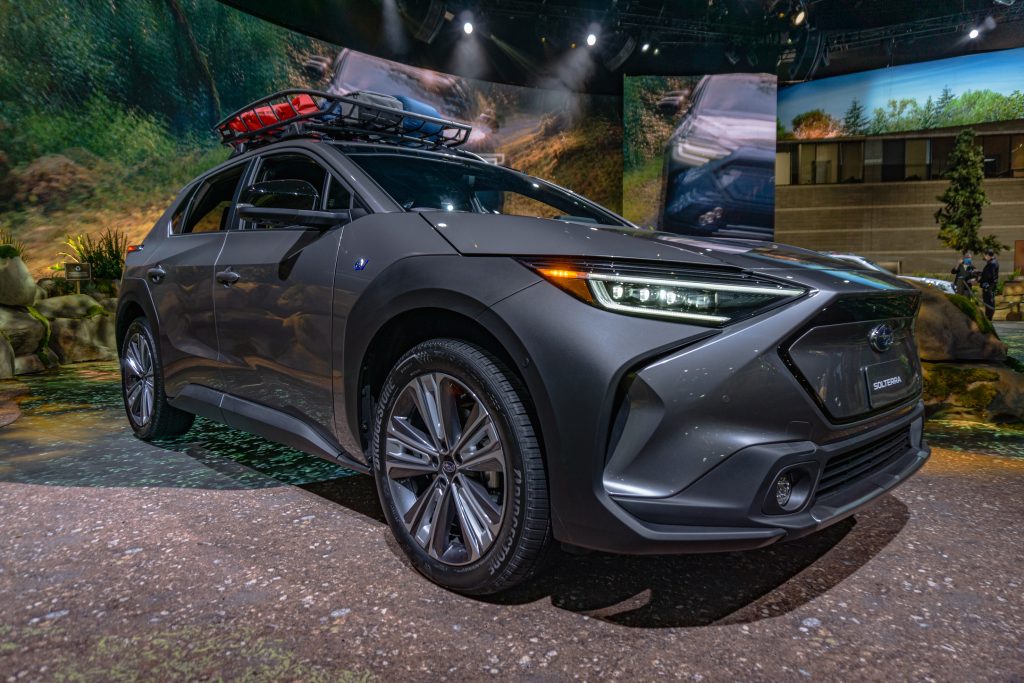 The front 3/4 view of a gray 2023 Subaru Solterra with a roof rack at the 2022 Chicago Auto Show