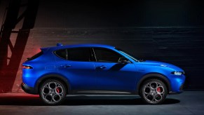 A blue 2023 Alfa Romeo Tonale against a black background.