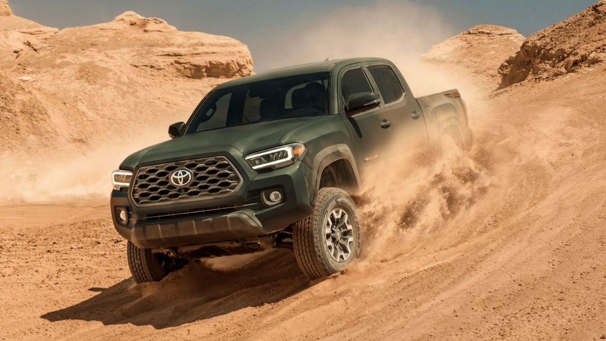 Army green 2022 Toyota Tacoma driving down a hill