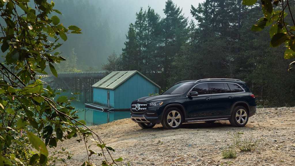 Black 2022 Mercedes-Benz GLS, the Consumer Reports least reliable luxury SUV for large families, parked near a lake