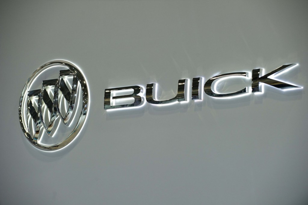 A silver Buick logo with white backlighting on a cream background.