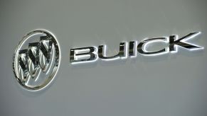 A silver Buick logo with white backlighting on a cream background.