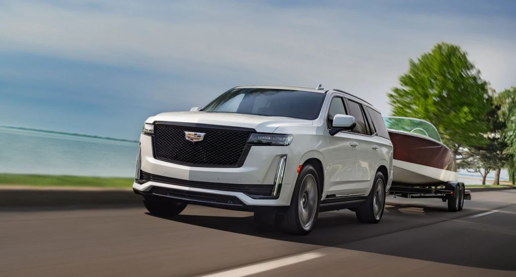 The Escalade utilizing its capability as a full-size SUV by towing a boat.