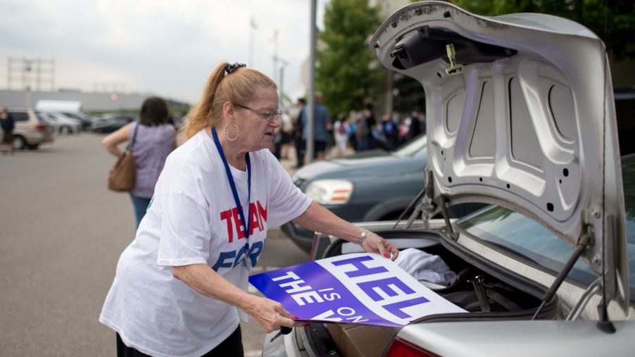 A Candian woman opening trunk and removing signs at the Toronto Congress Centre