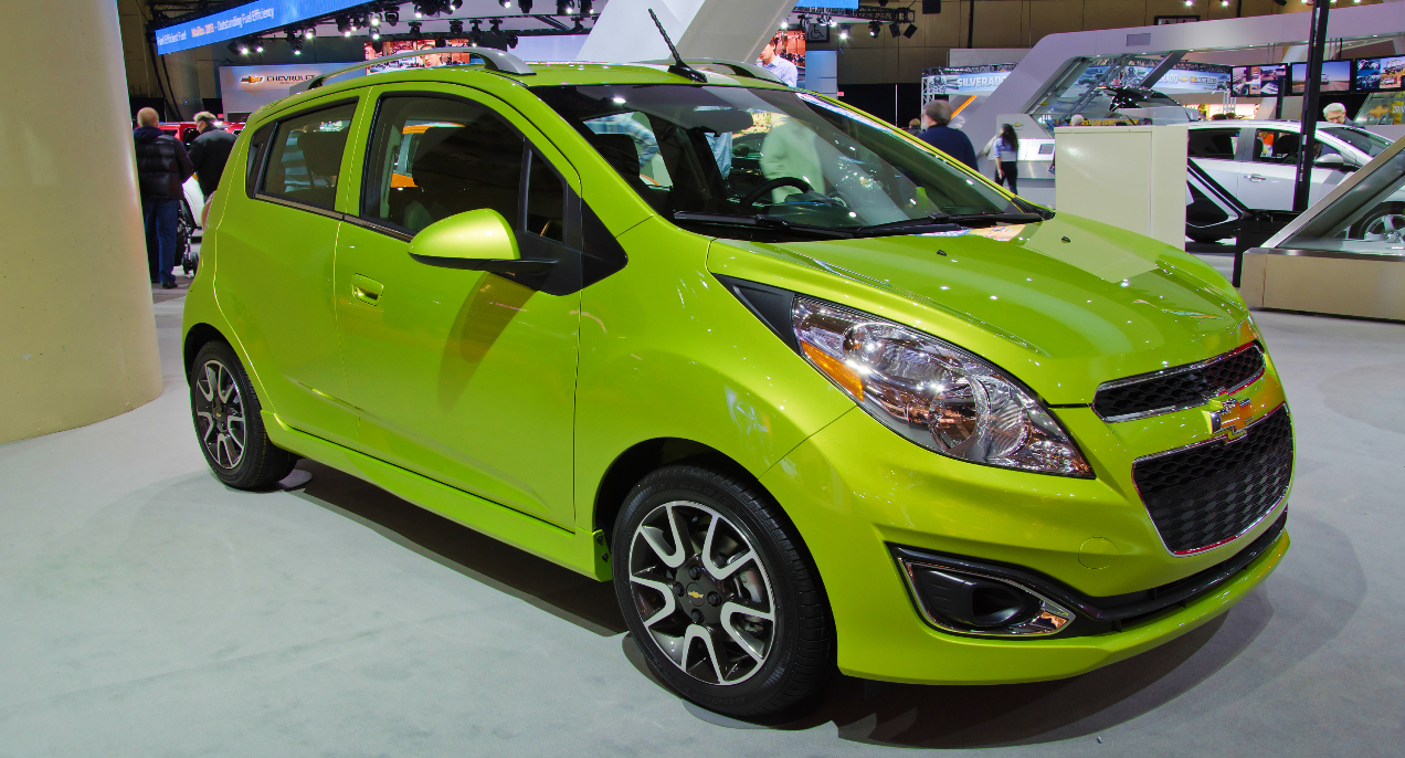 A green Chevy Spark small car is on display.