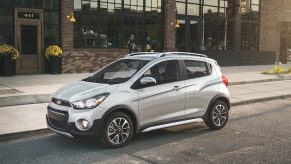 A silver Chevy Spark shot from the 3/4 angle on a city street
