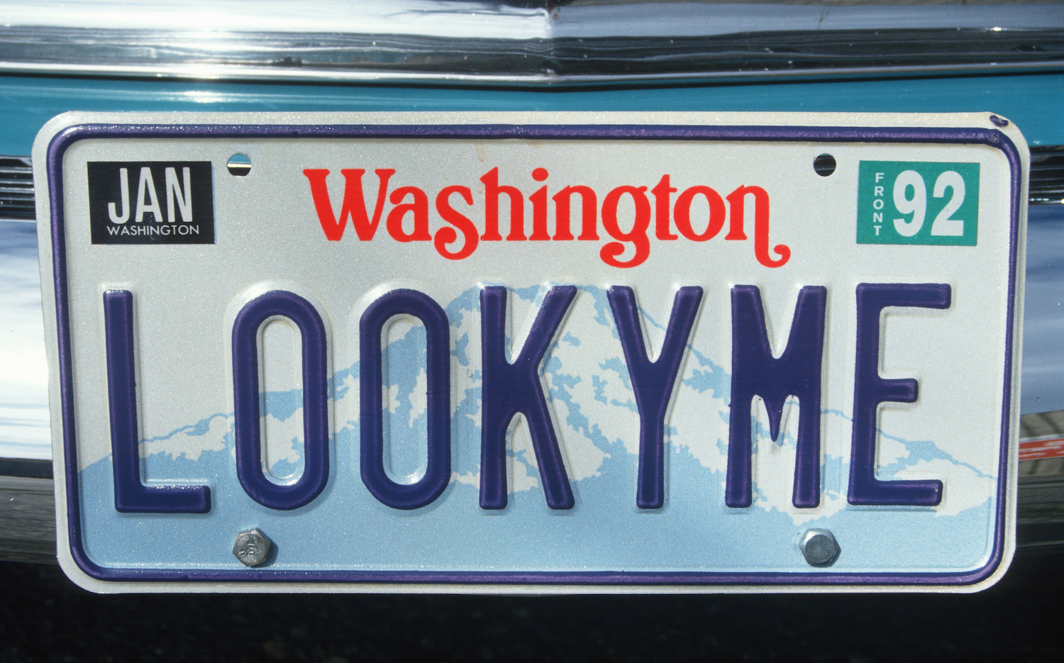 A blue on white Washington state license plate personalized to say "LookyMe"