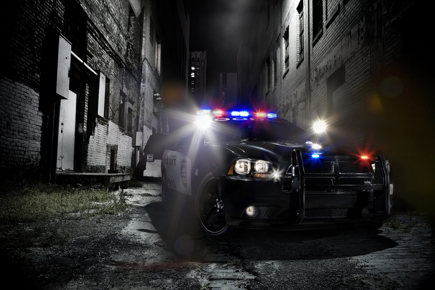 This is a Dodge Charger pursuit police vehicle parked in an alleyway with its lights flashing