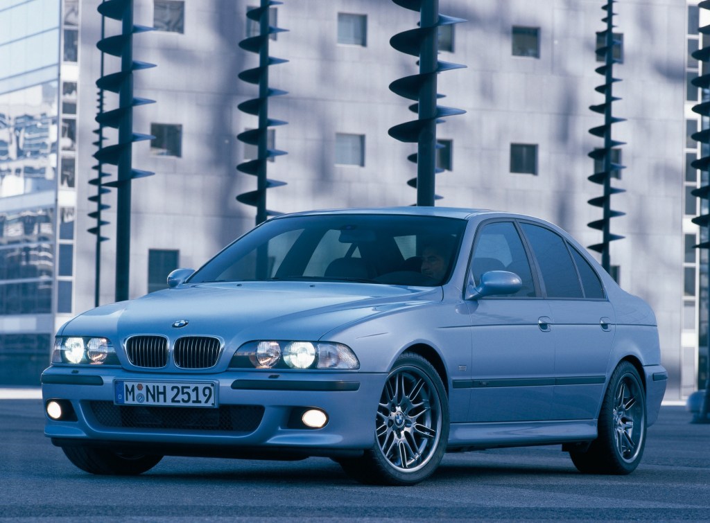 A silver E39 BMW M5 in a city parking lot
