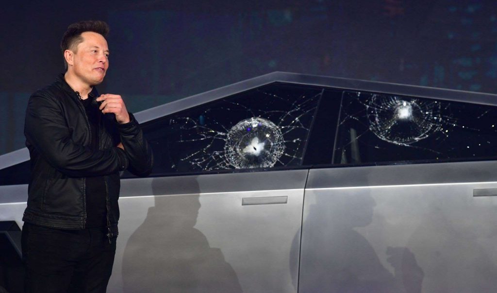 Elon Musk near Telsa Cybertruck with cracked windows, highlighting how Musk and Tesla are not loved by liberals anymore