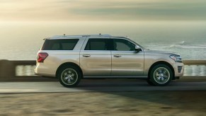 A beige 2022 Ford Expedition parked in front of a setting sun.