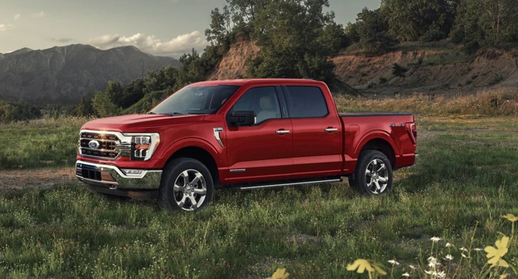 A red 2022 Ford F-150 full-size pickup truck is parked in grass. 