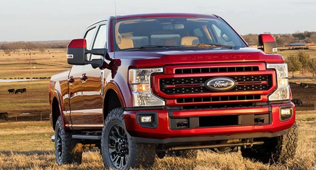 A red Ford F-350 heavy duty pickup truck is parked outdoors. 