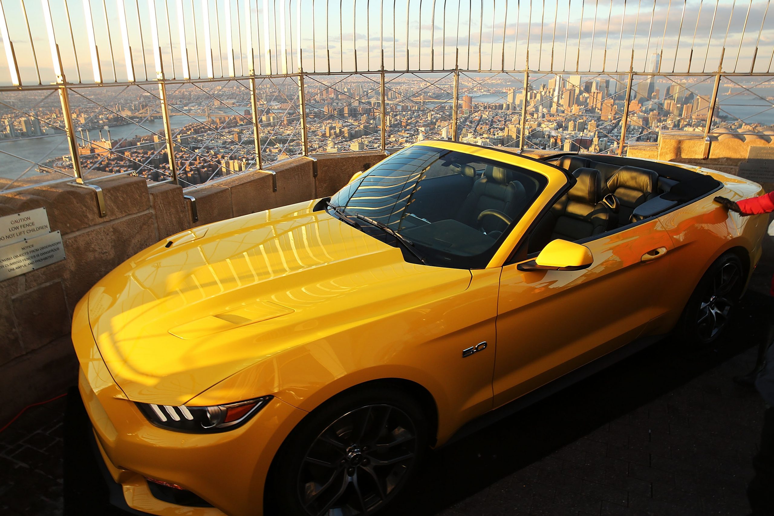 A Ford Mustang convertible car on the roof of the Empire State building