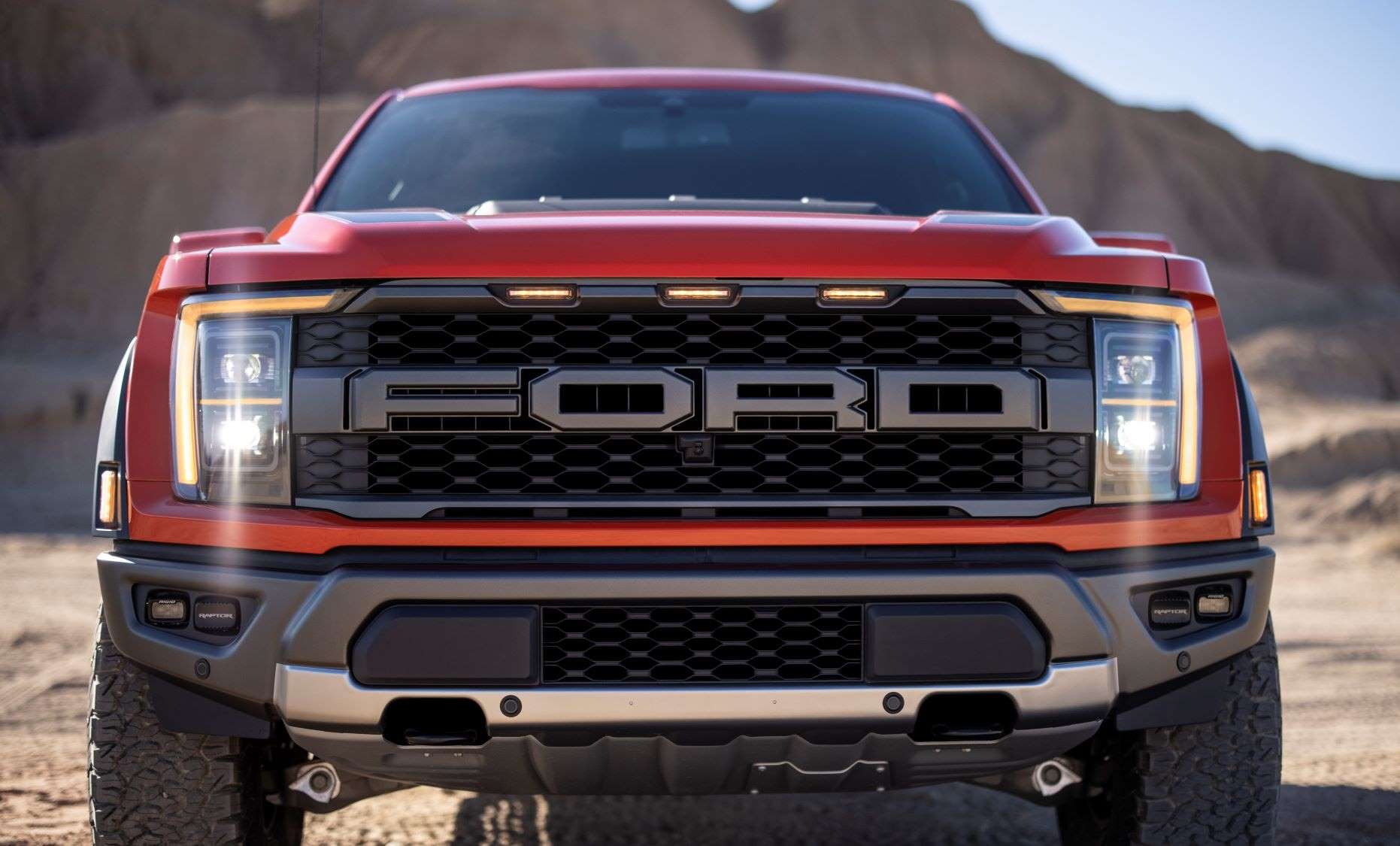 Front view of orange 2022 Ford F-150 Raptor, highlighting release date of F-150 Raptor R