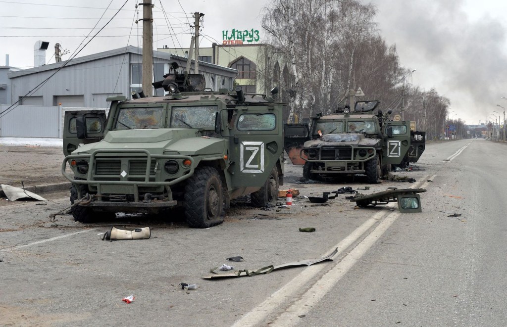 Two destroyed Russian troop transports on a Ukranian street in the aftermath of a firefight.