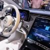 An interior view of a Mercedes-Benz EQS showing the steering wheel, dashboard and infotainment display.