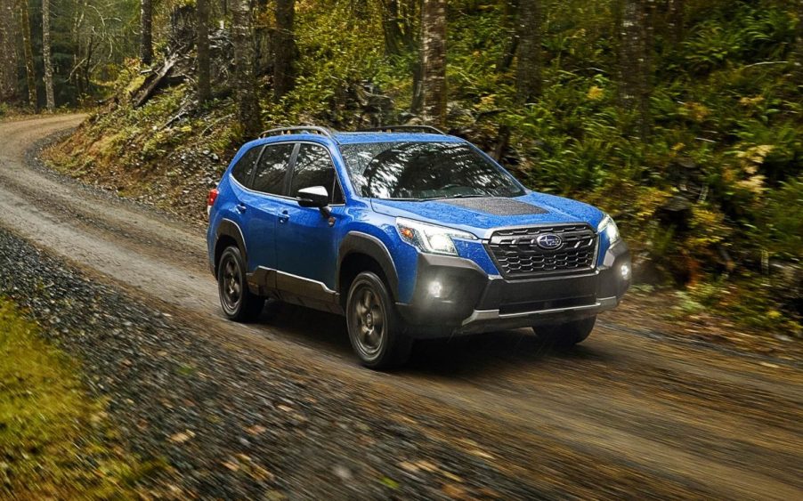 Geyser Blue 2022 Subaru Forester driving through a forest