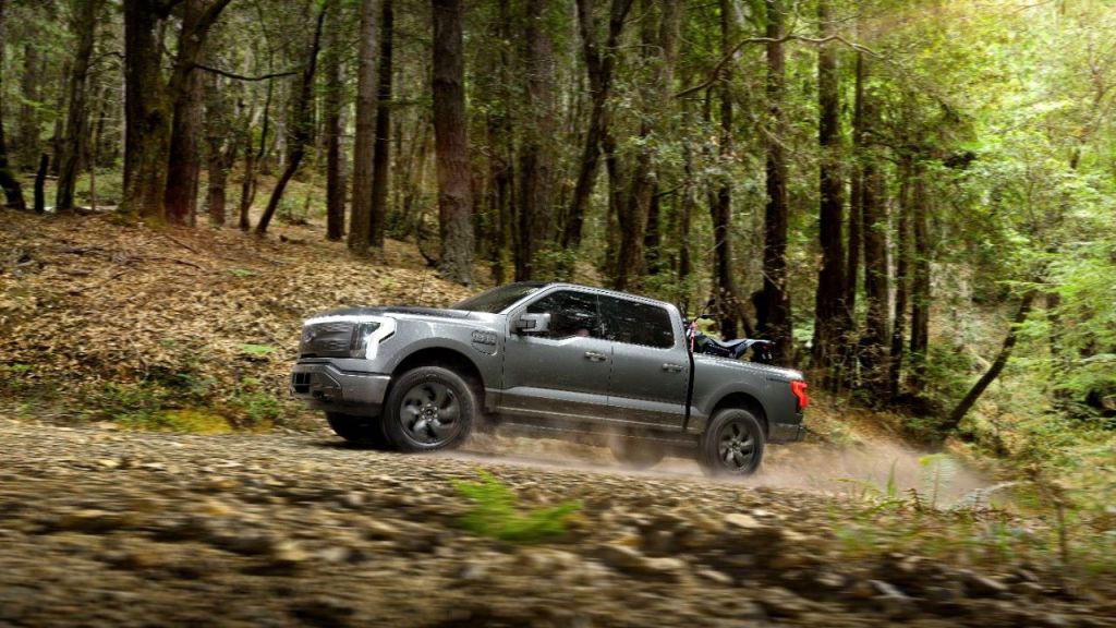 Gray 2022 Ford F-150 Lightning driving off-road, highlighting possible release of F-150 Lightning Raptor
