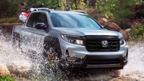 A gray 2022 Honda Ridgeline is driving through water.