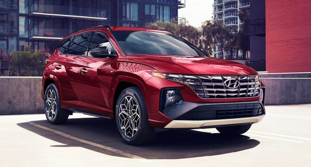 A red 2022 Hyundai Tucson compact SUV is parked on a parking complex.