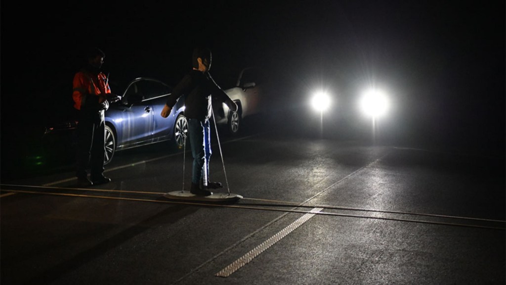 An IIHS monitors a nighttime pedestrian detection and automatic emergency braking test at night