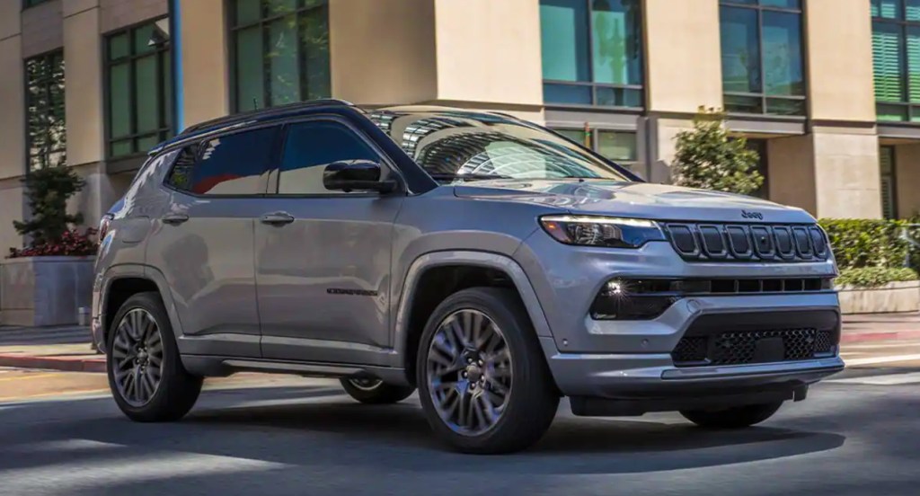A gray Jeep Compass 2022 small Jeep SUV is driving on the road. 
