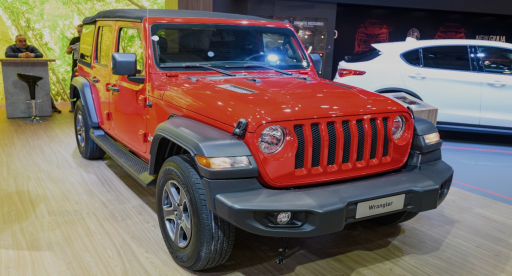A red Jeep Wrangler compact SUV is on display. 