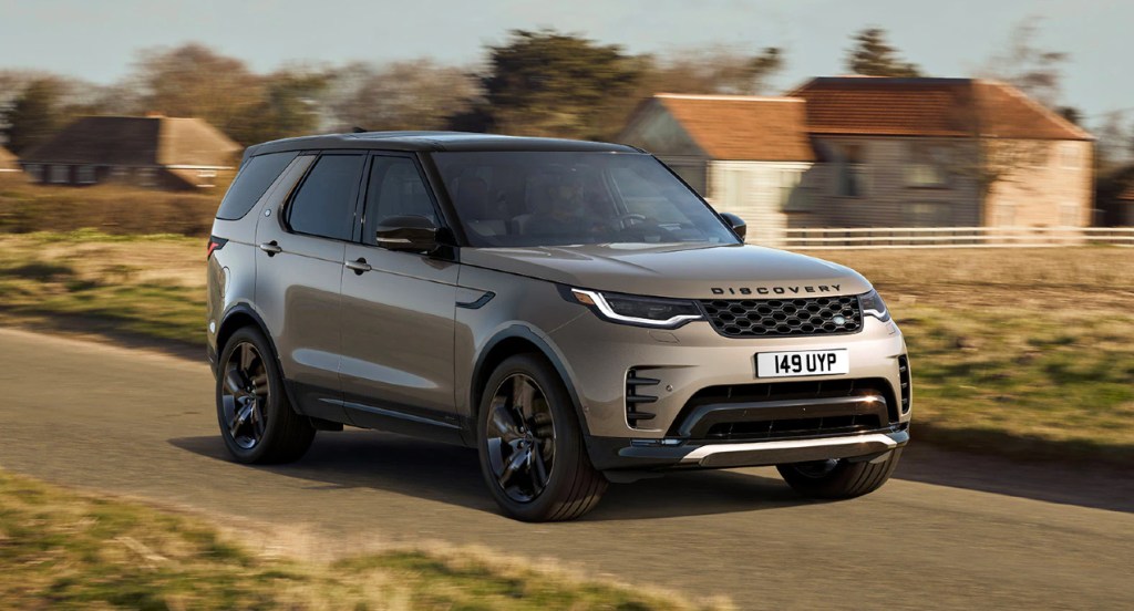 A gray Land Rover Discovery is driving on the road.