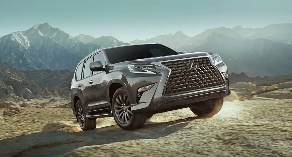 A gray Lexus GX midsize luxury SUV is driving off-road. 