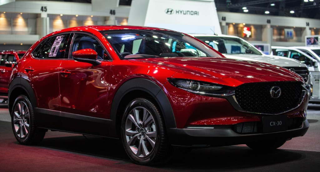 A red Mazda CX-30 subcompact SUV is on display. 