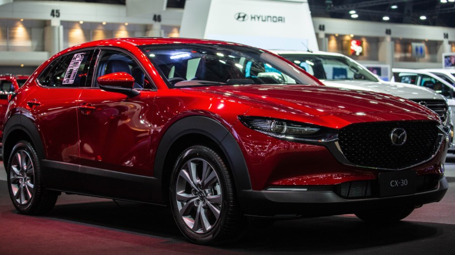 A red Mazda CX-30 is on display.