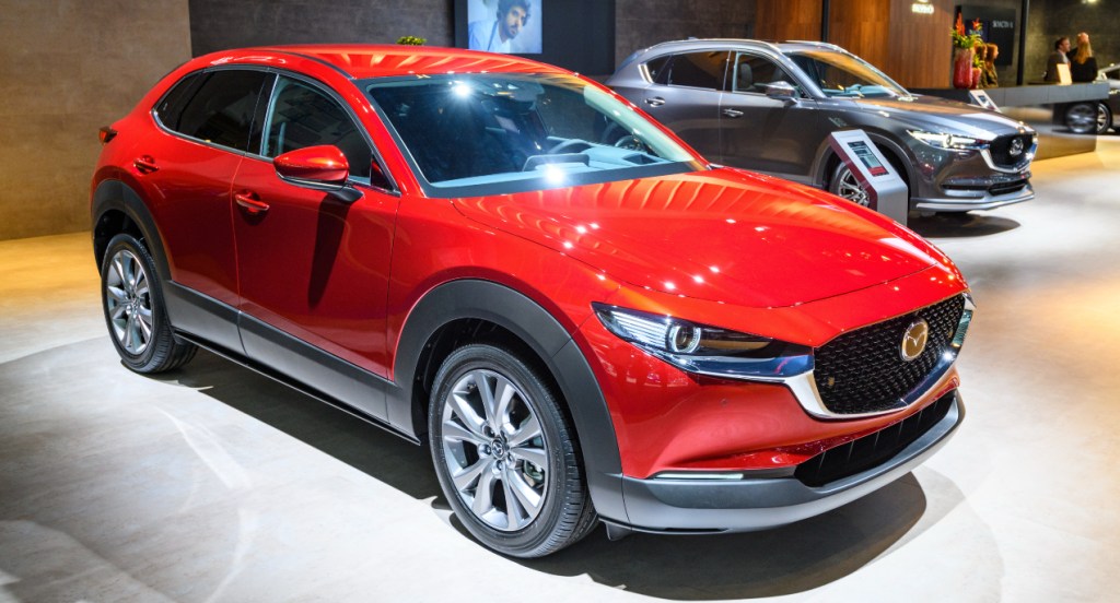 A red Mazda CX-30 small SUV is on display. 