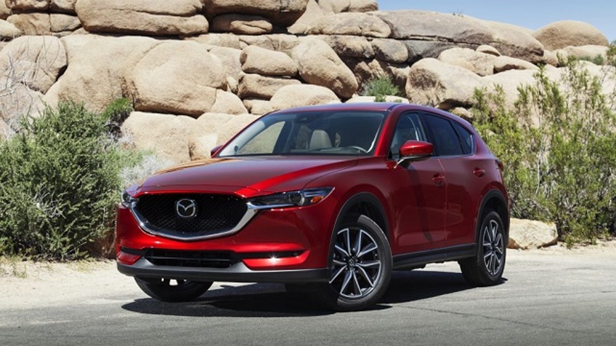 a red Mazda CX-5 with a rock formation background