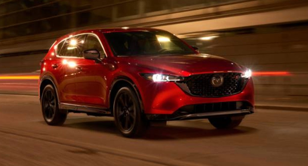 A red Mazda CX-5 is driving on the road. 
