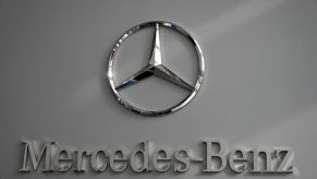 A chrome Mercedes-Benz logo on a gray background.
