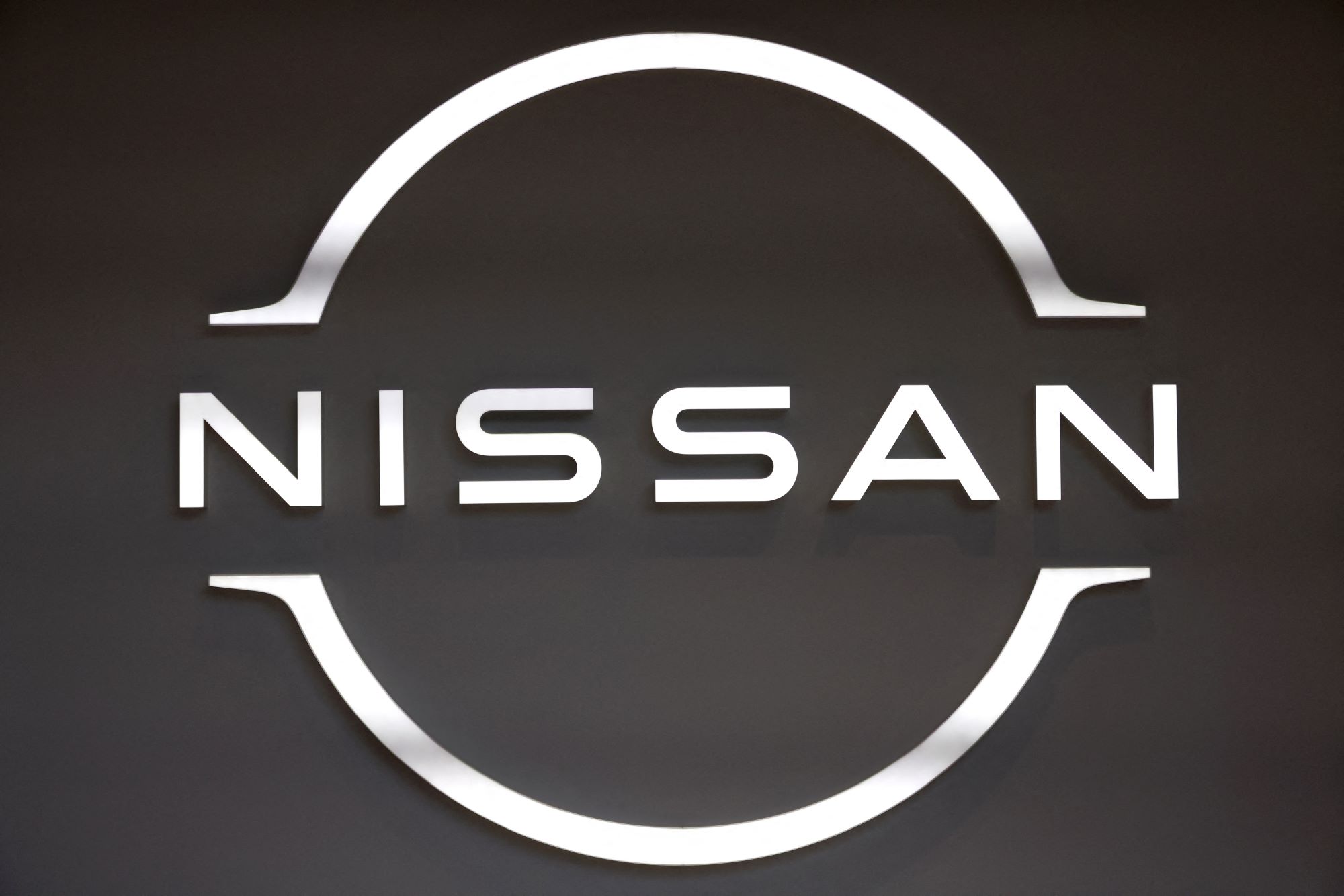 A white Nissan logo, maker of the Nissan Z series, on a black background.