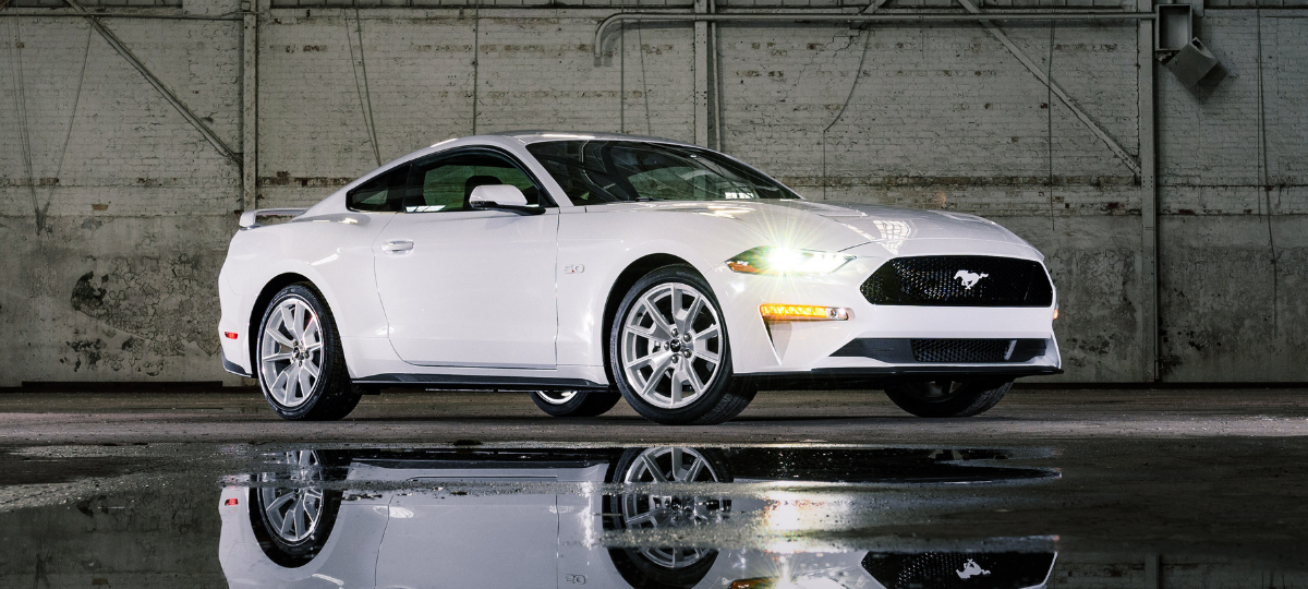 Passenger's side front angle view of white 2022 Ford Mustang, highlighting release date and price of 2023 Ford Mustang