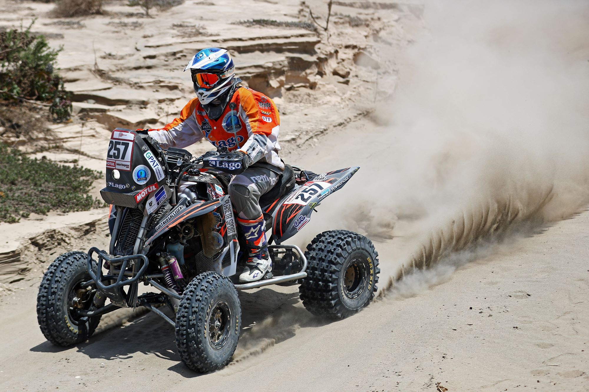 A person riding on an ATV in a dessert area.